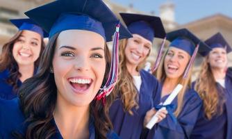 Happy Graduating Group of Girls In Cap and Gown Celebrating on Campus. photo