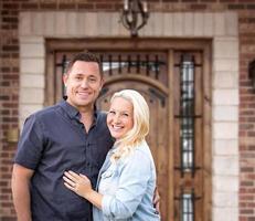 feliz pareja joven frente a la puerta principal de la nueva casa foto