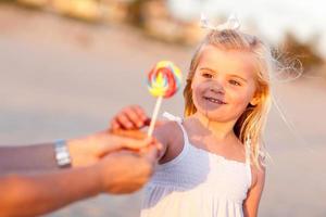 Adorable Little Girl Picking out Lollipop Outside photo