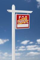 Right Facing Sold For Sale Real Estate Sign on a Blue Sky with Clouds. photo