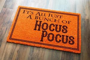 todo es un montón de hocus pocus alfombra de bienvenida naranja de halloween en el fondo del piso de madera foto