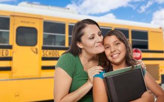 Hispanic Mother and Daughter Near School Bus. photo