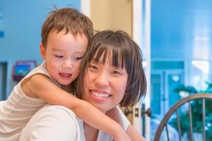 Happy Mixed Race Chinese and Caucasian Boy Having Fun with Chinese Mother Inside House photo