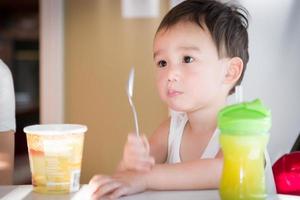 Cute Young Chinese and Caucasian Boy Enjoying Eating His Ice Cream photo