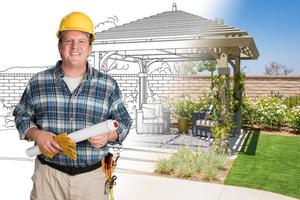 Male Contractor With House Plans Wearing Hard Hat In Front of Custom Pergola Patio Covering Drawing Photo Combination