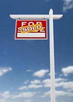 Left Facing Sold For Sale Real Estate Sign on a Blue Sky with Clouds. photo