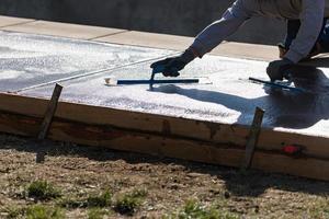 Construction Worker Smoothing Wet Cement With Trowel Tools photo