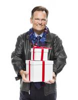 hombre vestido con chaqueta de cuero negro sosteniendo regalos de navidad en blanco foto