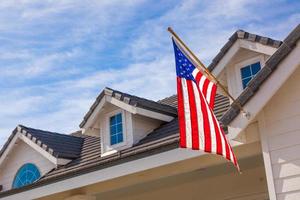 American Flag Hanging From House Facade photo