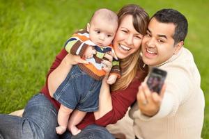 felices padres de raza mixta y niño tomando autorretratos foto