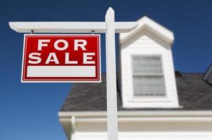 Left Facing For Sale Real Estate Sign In Front of House and Deep Blue Sky. photo