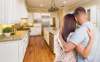 Young Hopeful Military Couple Looking At Custom Kitchen photo