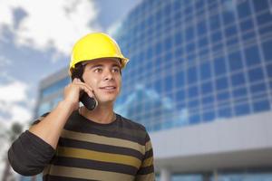 Hispanic Male Contractor on Phone in Front of Building photo