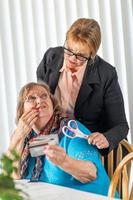 Financial Consultant Handing Scissors to Senior Lady Holding Credit Cards photo