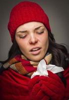 Sick Mixed Race Woman Blowing Her Sore Nose With Tissue photo