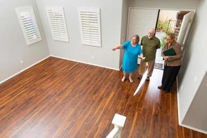 Female Real Estate Agent Showing Senior Adult Couple A New Home photo