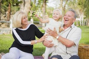 Affectionate Granddaughter and Grandparents Playing At The Park photo