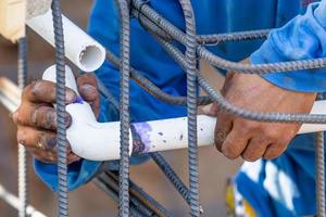 Plumber Installing PVC Pipe at Construction Site photo