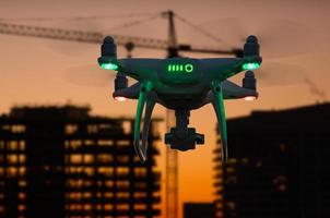 Silhouette of Unmanned Aircraft System Drone In The Air Over Buildings Under Construction photo