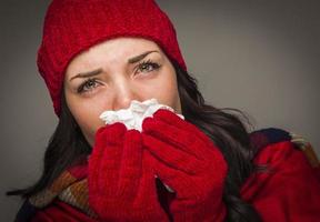 Sick Mixed Race Woman Blowing Her Sore Nose With Tissue photo