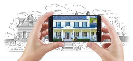 Hands Holding Smart Phone Displaying Home Photo of Drawing Behind