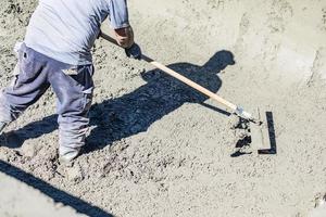 Pool Construction Worker Working With A Bullfloat On Wet Concrete photo