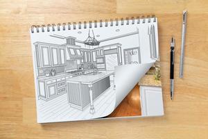 Sketch Pad on Desk with Drawing of Kitchen and Page Turning to Show Finished Construction Next To Pencil, Ruler photo