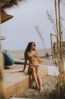 Young woman in bikini standing by the beach bar on a summer day photo