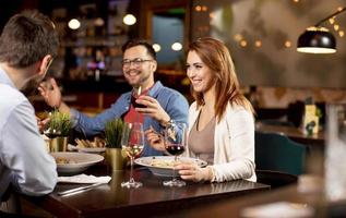 Young people having dinner in the restaurant photo