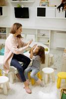 Nursery teacher talking to little girl in the kindergarten photo