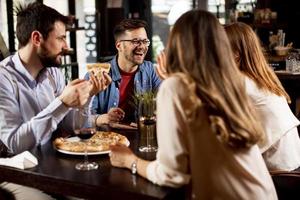 Young people having dinner in the restaurant photo