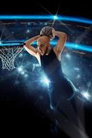 jugador de baloncesto en camiseta negra hace una volcada en el juego foto