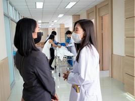 doctor nurse female person talk speak discussion woman lady people indoor room hospitalclinic laboratory wear mask. emergency word accident health care treatment visit family teamwork medical photo