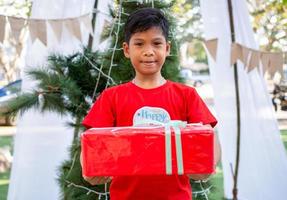 Boy holding presents on Christmas celebration.Christmas festival. photo