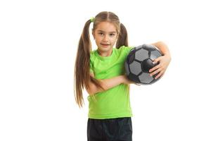 Pretty young girl in green shirt with ball in hands photo