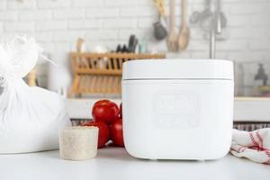 Electric rice cooker on wooden counter-top in the kitchen photo