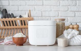 Electric rice cooker on wooden counter-top in the kitchen photo