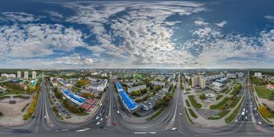 aerial full seamless spherical hdri 360 panorama view above road junction with traffic in city overlooking of residential area of high-rise buildings in equirectangular projection. photo
