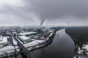 ariel panoramic view of city and skyscrapers with a huge factory with smoking chimneys in the background photo