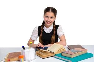 Cheerful young schoolgirl in uniform studying photo