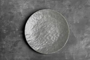 Empty grey textured plate in center of dark grey. Monochrome minimal image. Top view. Mock up. photo