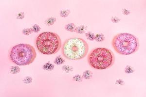 Top view pattern of five glazed donuts and flowers of lilac. photo