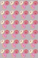 patrón de moda sin costuras de donuts tradicionales con esmaltes lilas, blancos y morados en gris. orientación vertical. foto