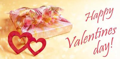Festive banner with trendy wrapped gift box, flowers Alstroemeria, two hearts and words Happy Valentines day on yellow. photo