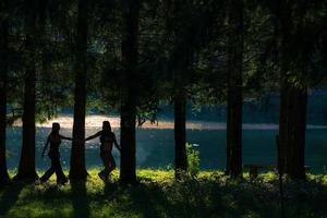 bonitas chicas hippies libres caminando por el bosque. vista al lago - foto de efecto vintage