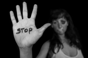 Stop violence against women. Woman with mouth closed by patch and hand written stop
