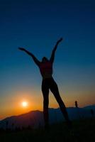 Silhouette of woman at sunset in the mountains photo