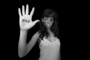 Stop violence against women. Woman with mouth closed by patch and hand written stop photo