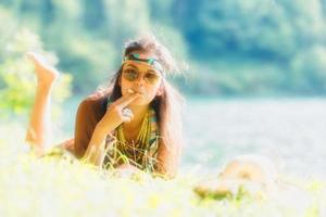 chica hippie bastante libre fumando en la hierba - efecto de foto vintage