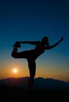 Silhouette of woman at sunset in the mountains photo